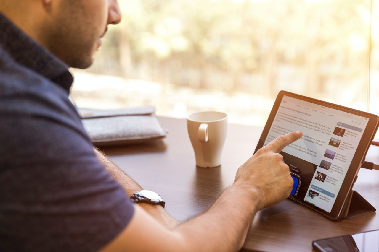 man browsing internet on tablet