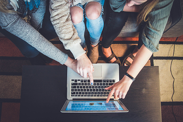 hands pointing at computer screen